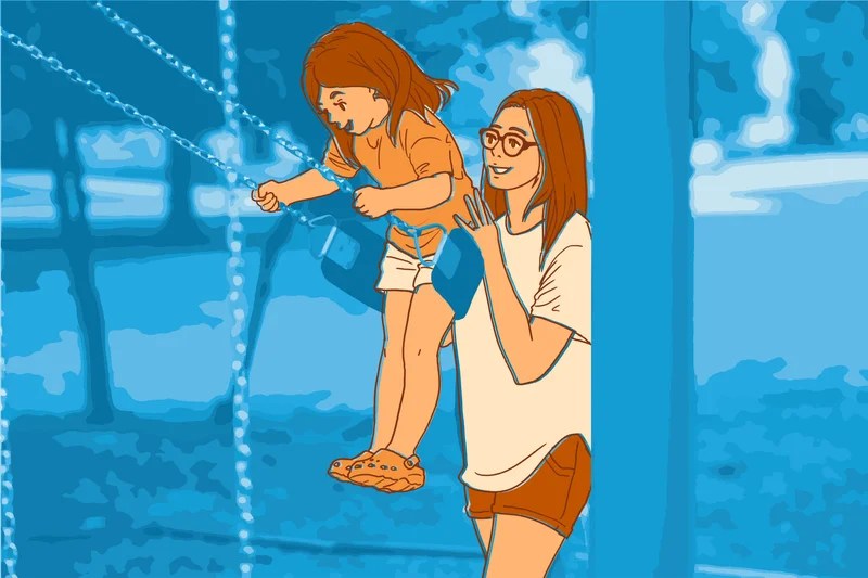 Parent supporting a child on a playground swing