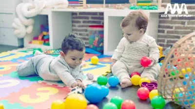 Preschool child engaging in onlooker play by observing other children playing nearby.